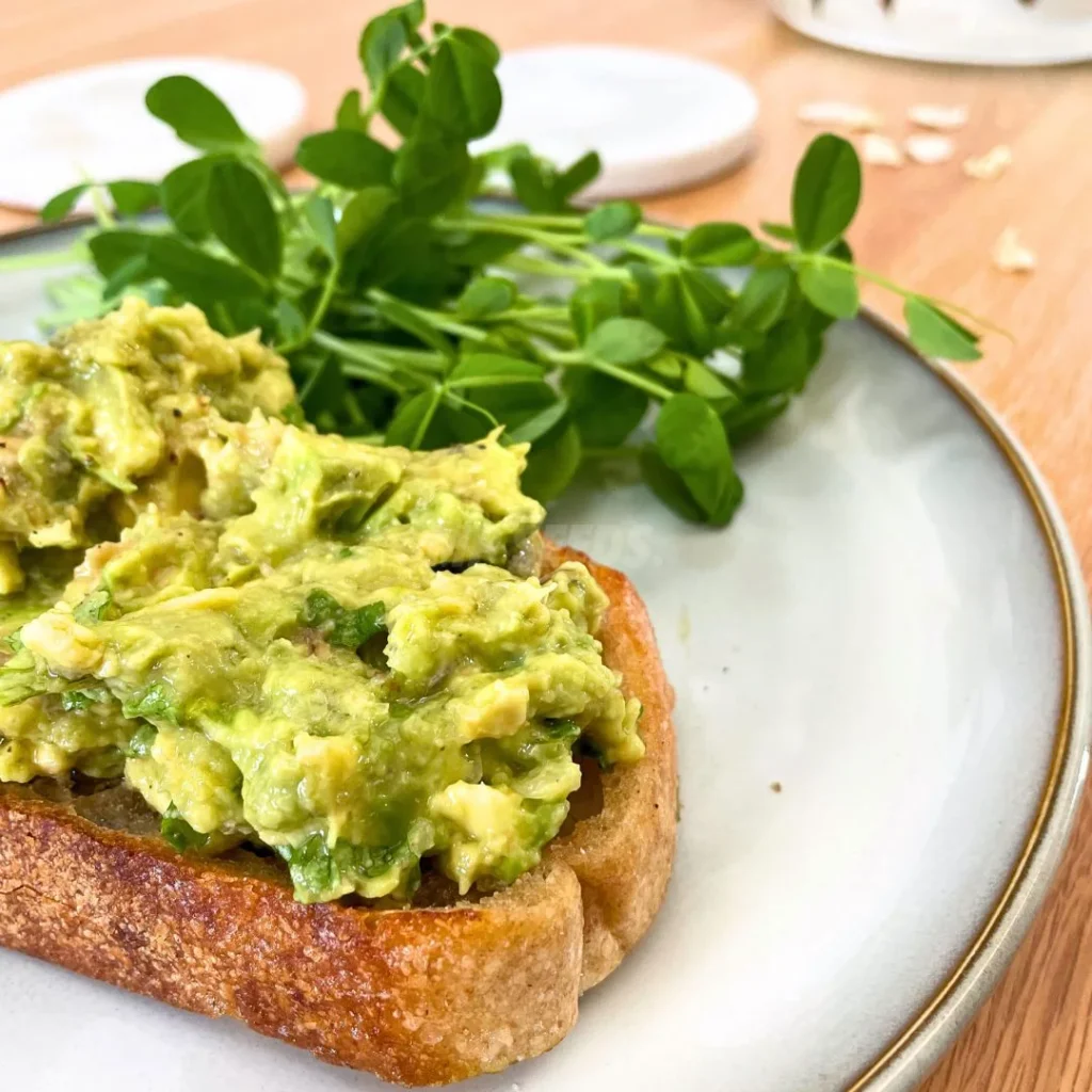 Una tostada con crema de aguacate con microgreens frescos